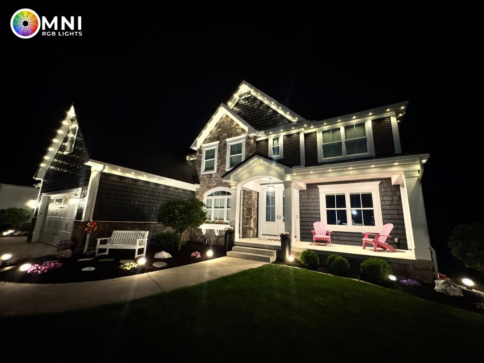 Warm white permanent lighting on a two-story home with a lit front porch